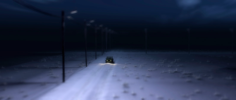 A car drives along a deserted, snow-covered road by night