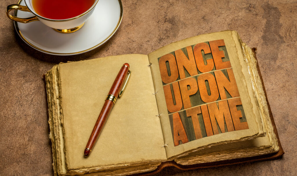A notebook open on the words ONCE UPON A TIME with a pen ready to start writing