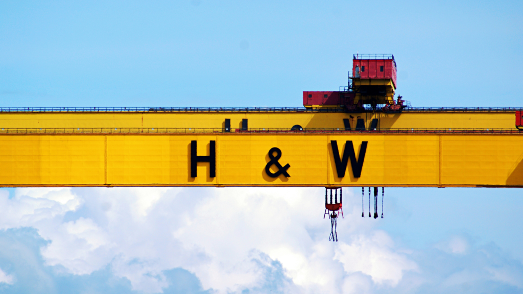 Image of two bright yellow crane arms with the letters H&W embossed in black