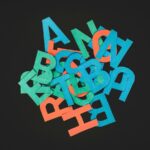A jumbled mess of wooden letters against a black background