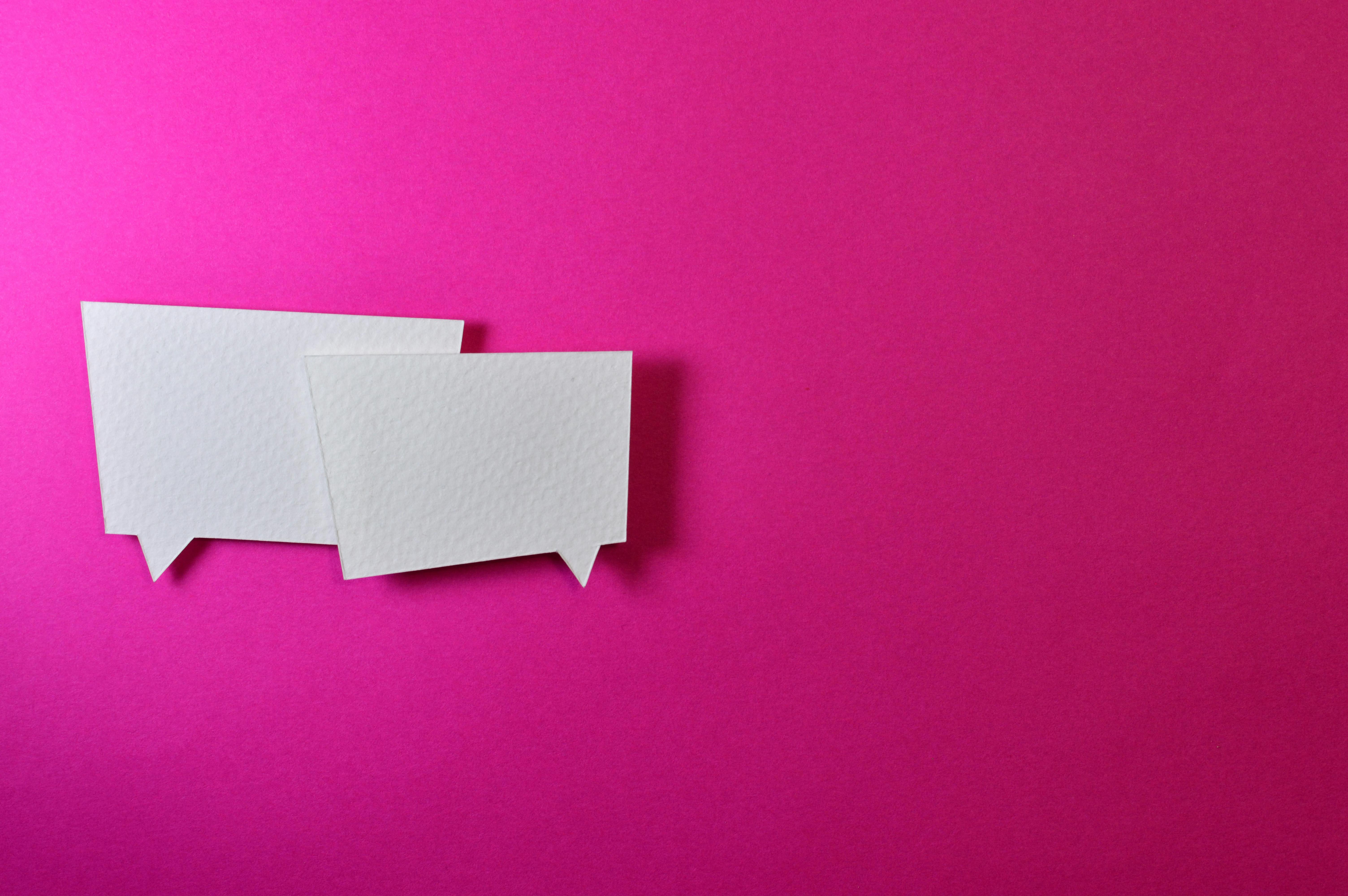 two white dialogue boxes against a hot pink background