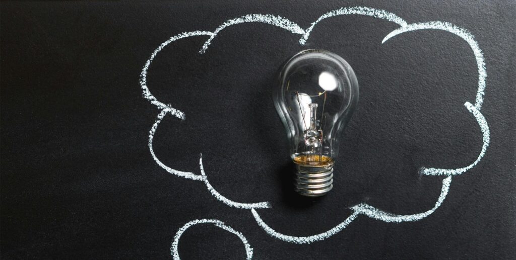 Clear Light Bulb Placed on Chalkboard