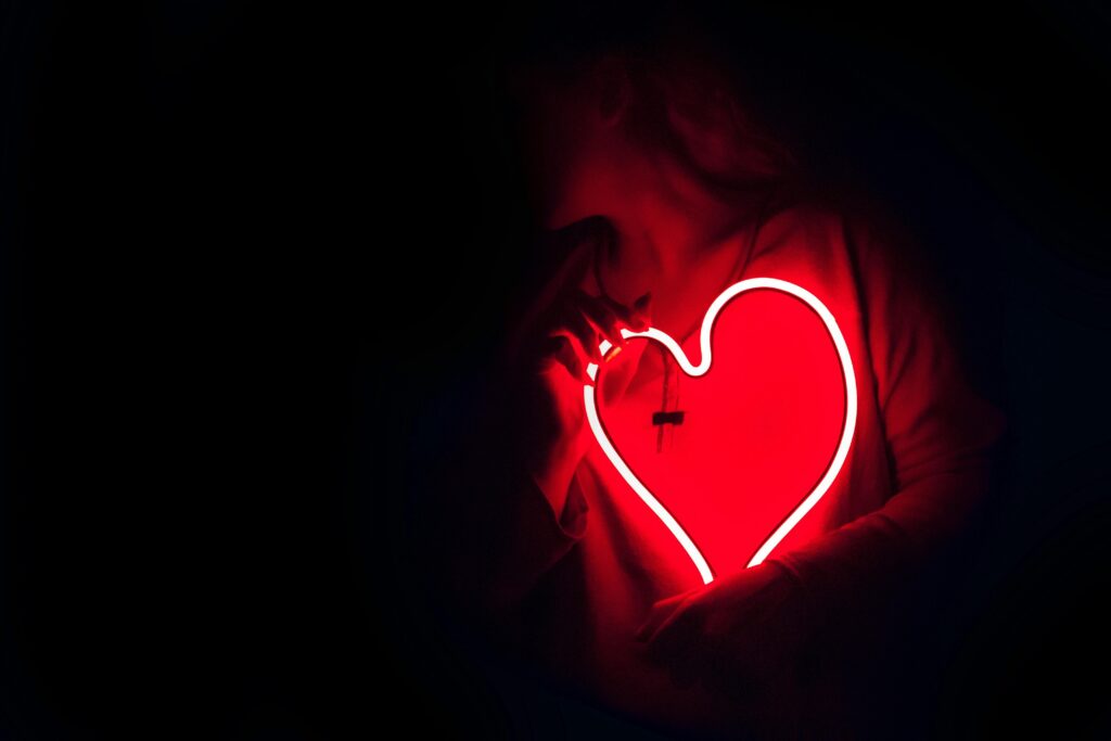 A neon heart in a dark room