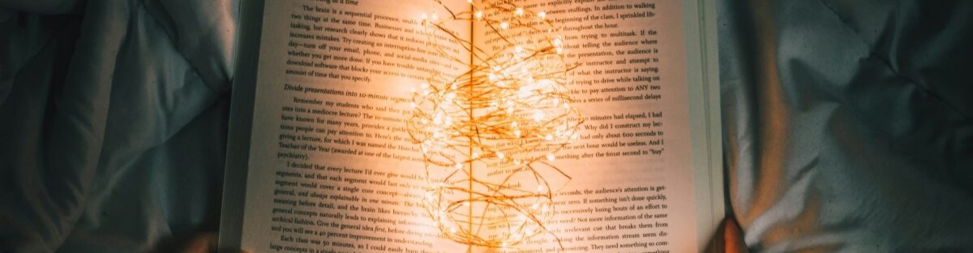 book open in the middle and lit up by fairy lights